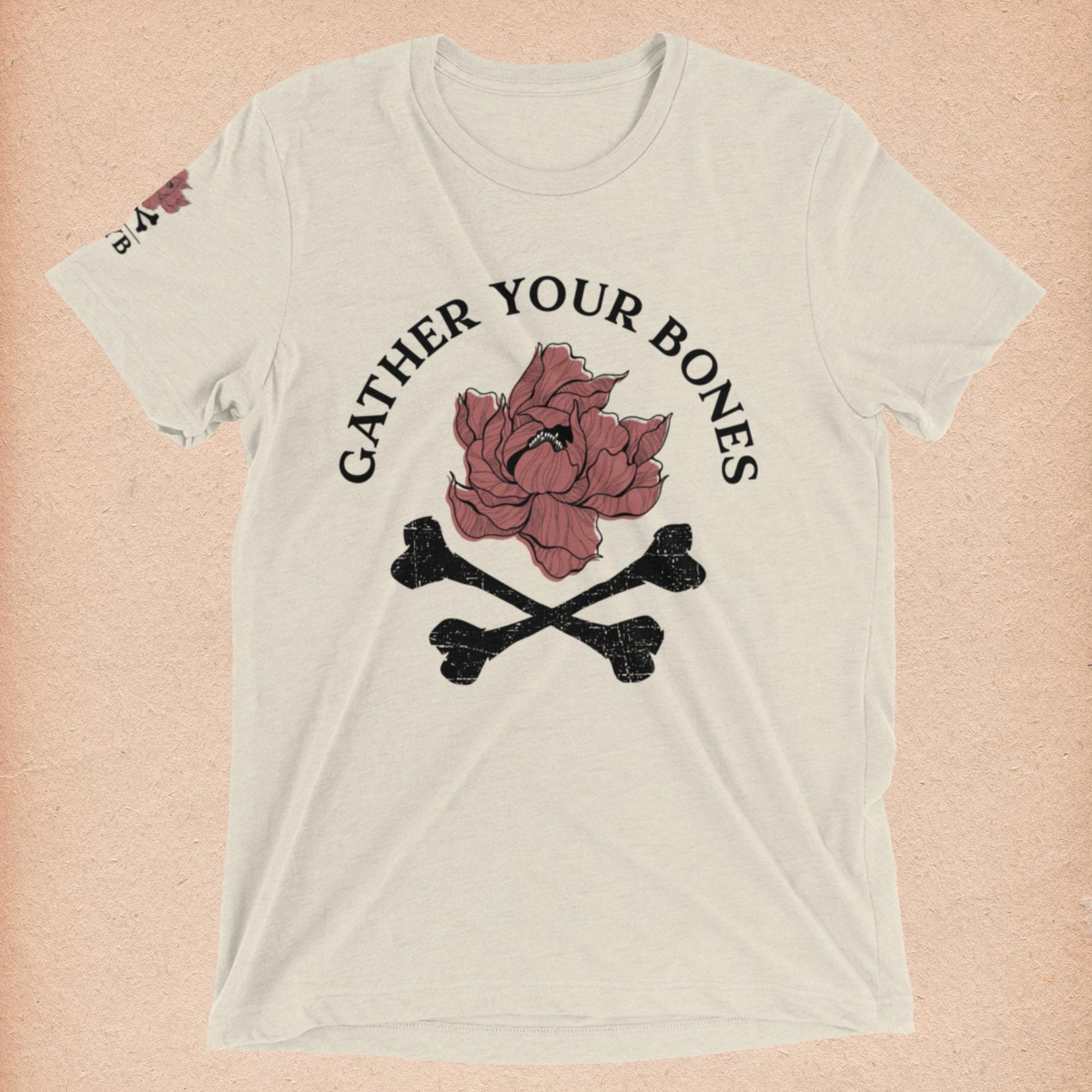 Oatmeal Short-Sleeved T-Shirt with "Gather Your Bones" peony and crossbones logo